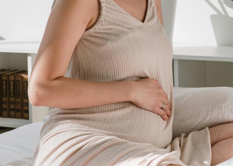 Schwangere Frau deren Hand auf ihrem Bauch liegt